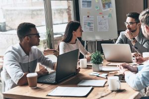 Successful business team. Group of young modern people in smart casual wear discussing business while sitting in the creative office